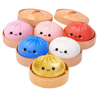 Set of colorful bun-shaped squishies with faces in a steamer-like container 