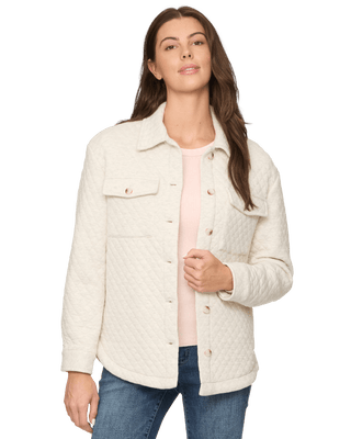 Woman wearing cream quilted knit shacket with button front over pink top and jeans