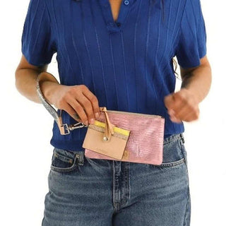 Person holding a pink and gold clutch purse 
