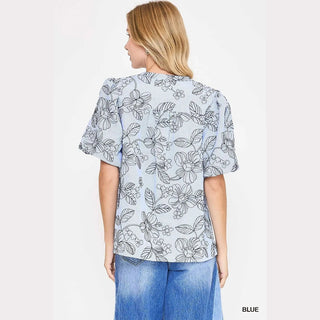 Woman wearing a floral blouse with blue jeans 