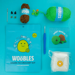 The Woobles Emilio the Turtle beginner crochet kit with green and brown yarn, hook, and accessories