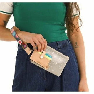 Person holding a colorful wallet with a neutral strap 
