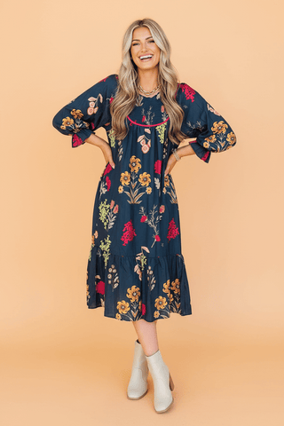 Navy floral midi dress with puff sleeves, smocked neckline, and tiered ruffle hem