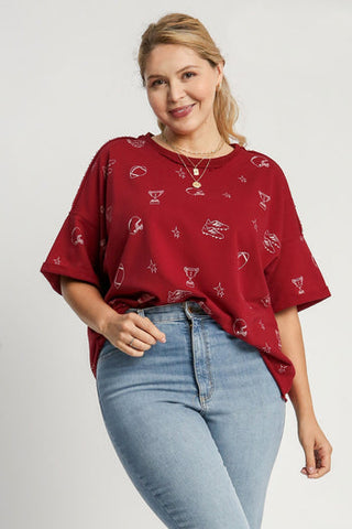 Woman wearing wine red French terry oversized top with white sports graphic print and jeans