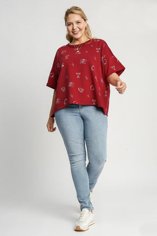 Woman wearing wine red French terry round neck top with small print pattern and light wash jeans