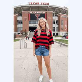 Red black striped spirit wear top featuring dropped shoulders at Texas Tech campus