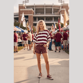 Maroon cream striped knit top with loose fit at sunny stadium tailgate gathering