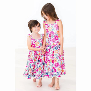 Two children wearing floral dresses 