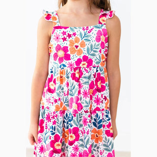 Child wearing a floral dress with pink, orange, and blue flowers 