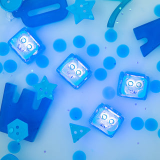 Glo Pals Blair light-up sensory cubes glowing blue in water with blue foam shapes