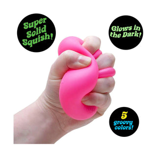 Compressed hot pink Nee Doh Nice Cube Glow demonstrating super solid squish texture and bounce back