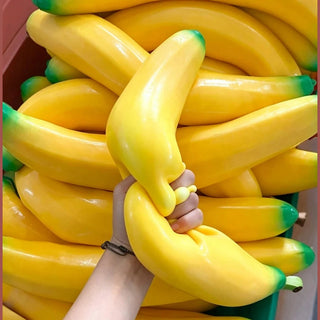 Stacked giant banana squishies in plastic crates for retail display