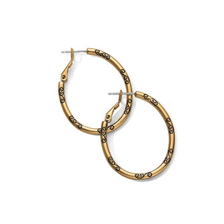 Close-up of Brighton gold oval hoop earrings featuring black scroll engravings and hinged fishhook closures