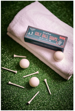 Gentlemen's Hardware Golf Ball Soaps box with three round white soaps and golf tees on turf