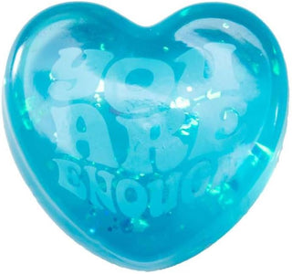 Close-up teal NeeDoh squishy heart with 'You Are Enough' text and internal glitter texture
