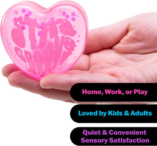 Pink NeeDoh squishy heart with 'Stay Groovy' text held in palm for portable sensory relief