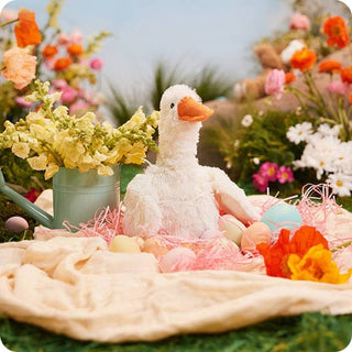 White lavender scented Warmies goose in spring Easter scene with flowers