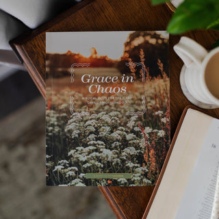 Grace in Chaos Bible study booklet on wooden table beside open Bible and coffee