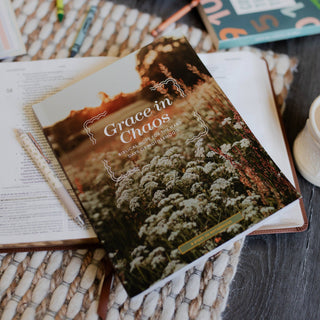 Grace in Chaos Bible study booklet on open Bible with pen and coffee mug