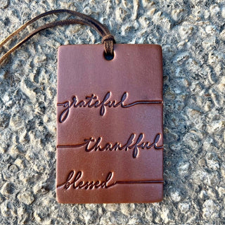 Brown leather air freshener tag engraved with grateful, thankful, blessed on leather cord