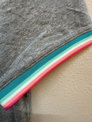 Grey heathered top with teal, mint, white, coral, and pink striped hem detail