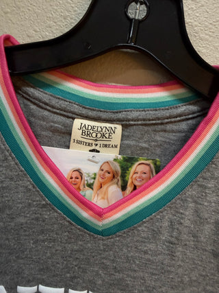 Grey v-neck top with rainbow striped collar trim on black hanger