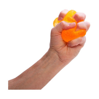 Orange jelly-like NeeDoh Gumdrop being squeezed by adult hand