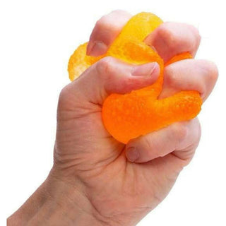 Orange pliable NeeDoh Gumdrop squishy compressed in hand close-up