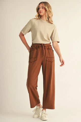 Beige half sleeve mock neck sweater top paired with brown wide-leg pants