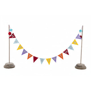 Happy Birthday banner with colorful triangle pennants strung between two wooden posts with pom-pom toppers