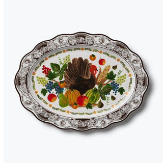 Oval white porcelain platter with turkey, harvest fruits, and dark floral scalloped border
