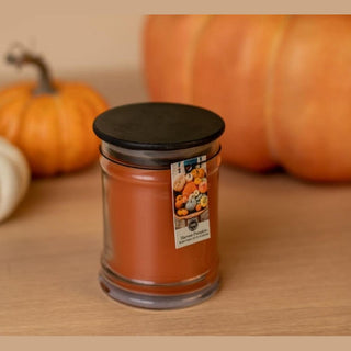 Close-up of Harvest Pumpkin 8oz candle highlighting smooth orange-amber wax and cylindrical glass jar