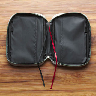 Open olive green zippered Bible cover with black interior pockets and ribbon bookmarks