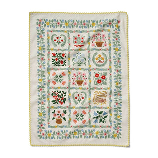 Embroidered tea towelwith floral and botanical patterns 