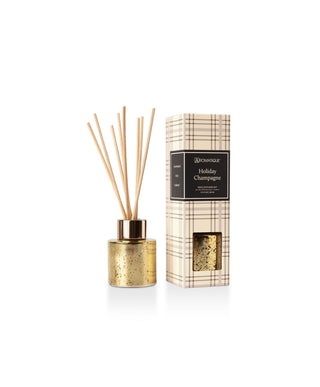 Aromatique Holiday Champagne Mini Reed Diffuser in gold vessel with plaid packaging box