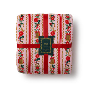 Rifle Paper Co Holly Jolly fleece blanket folded with red ribbon and branded tag