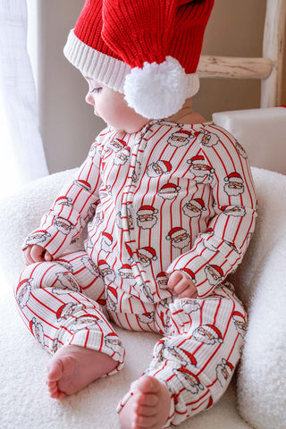 Baby wearing Caden Lane Santa print bamboo waffle zipper romper with matching red Christmas hat