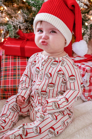 Baby wearing Caden Lane Holly and Jolly Santa print Christmas romper with matching Santa hat
