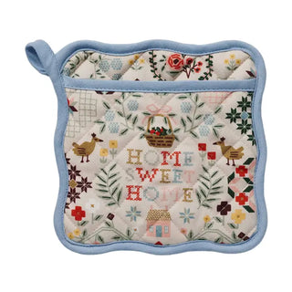 Quilted pot holder with floral and nature-themed design 