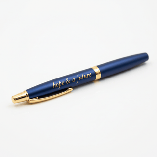Close-up detail of gold laser-engraved hope & a future text on navy pen