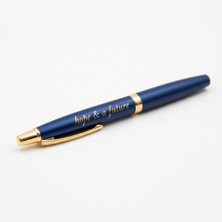 Close-up detail of gold laser-engraved hope & a future text on navy pen