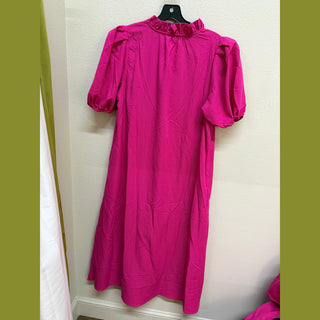 Back view of hot pink A-line dress with ruffled high neckline and elastic cuffs
