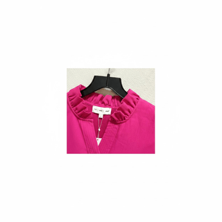 Close-up of hot pink dress back ruffled collar with brand tag and ribbed texture