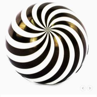 Black and white spiral design on a round object with gold accents