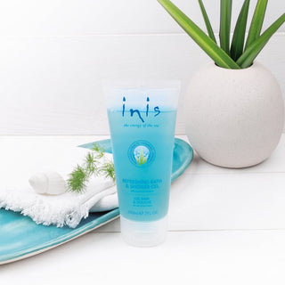 Blue tube of 'inis' product on a white surface with a plant and towel 