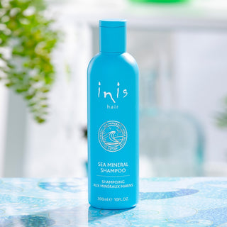 Blue shampoo bottle labeled 'inis hair' on a blue surface 