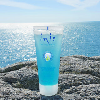 Blue tube of Inis skincare product on a rock with ocean