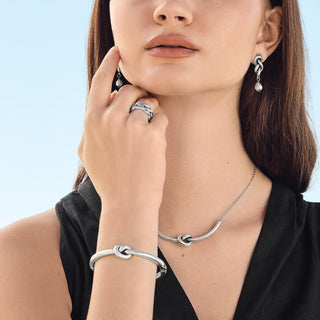 Model wearing Brighton Interlok Single Knot Hinged Bangle in silver on wrist with matching jewelry set