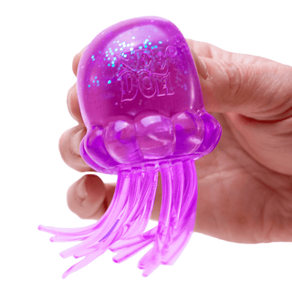 Hand squeezing a purple glitter jellyfish-shaped Nee Doh stress toy with tentacles