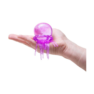 Hand holding a small purple glittery jellyfish-shaped Needoh stress ball toy